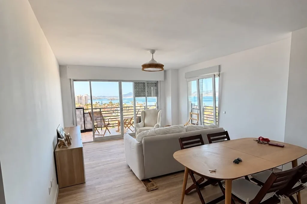 Salón reformado con suelo de madera y vistas al mar en Cartagena